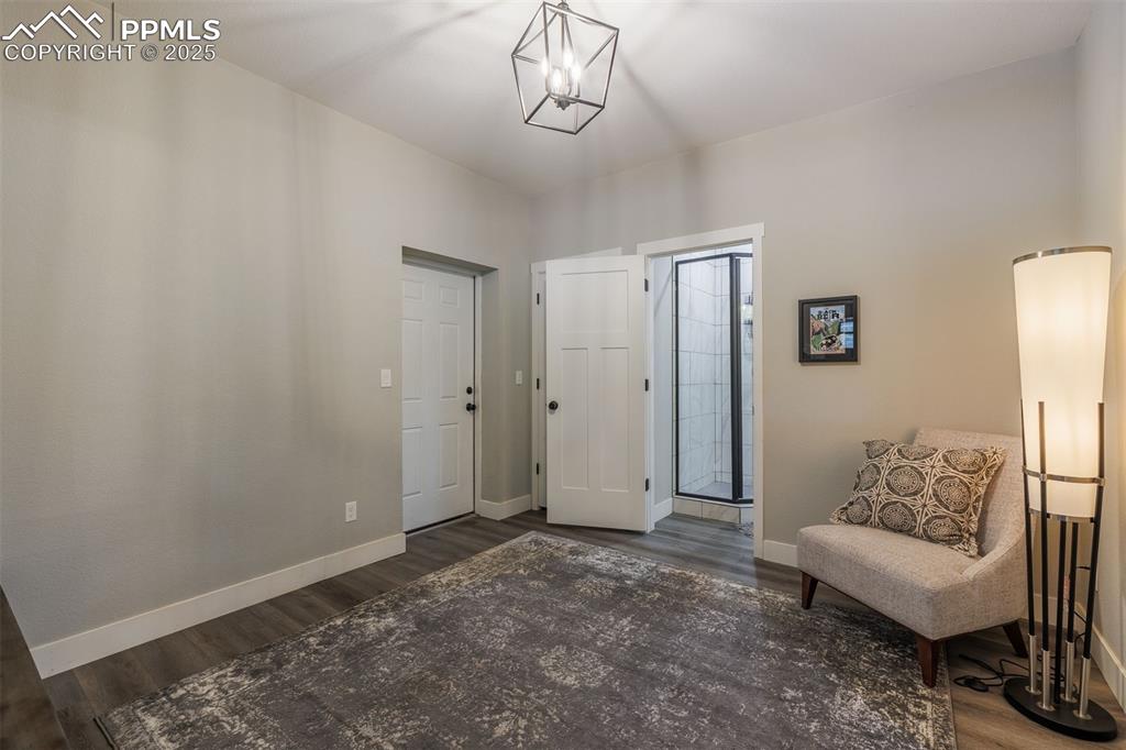 Image 9 of 38: Living area with dark wood-style flooring and a chandelier