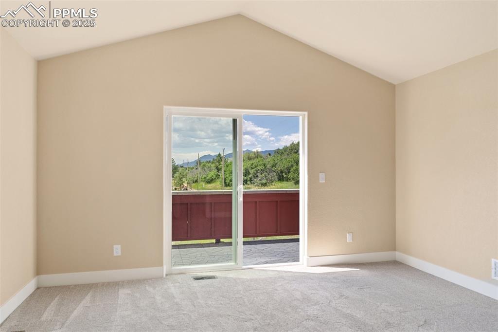 Image 15 of 33: Primary bedroom suite with private balcony with stunning Front Range views