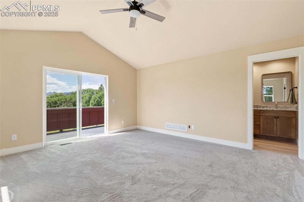 Image 16 of 33: Primary bedroom suite with private balcony with stunning Front Range views