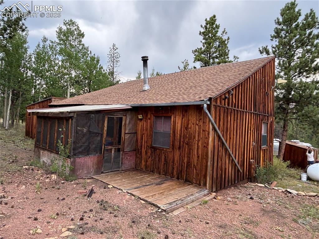 Image 10 of 40: Back of property featuring a sunroom, a shingled roof, and a deck