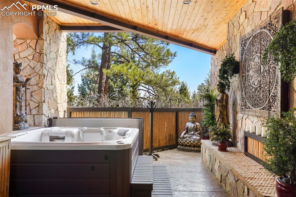 Image 43 of 50: Covered patio with hot tub