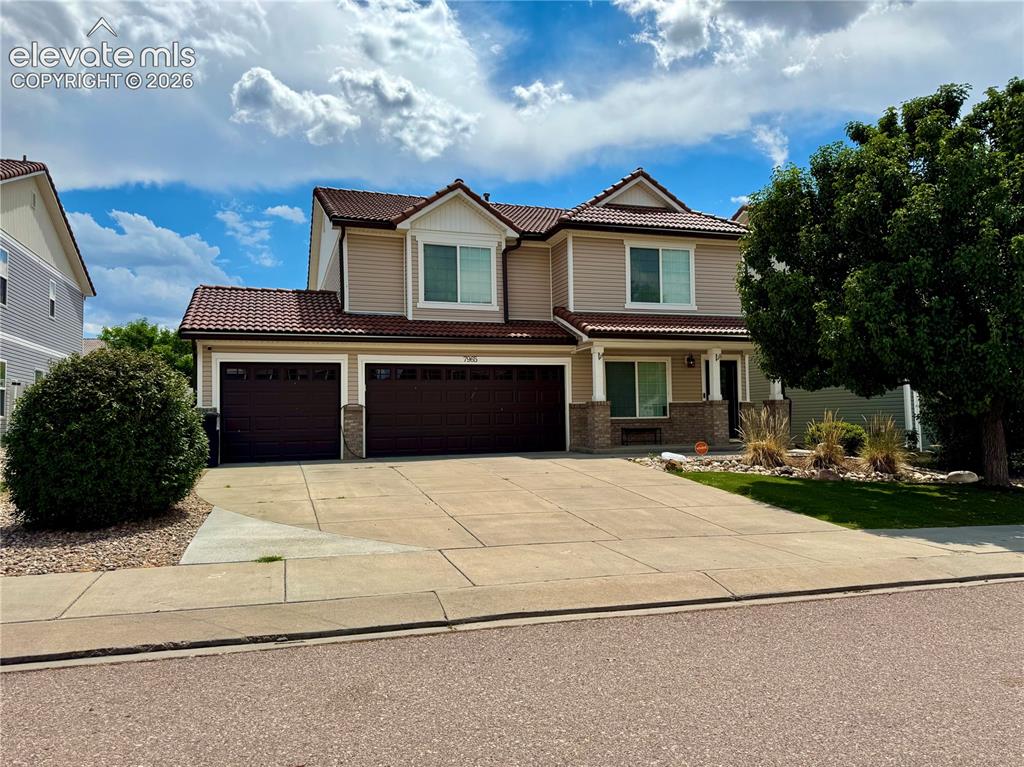 Image 1 of 36: Two-story residence featuring a terracotta-style tile roof and tan siding