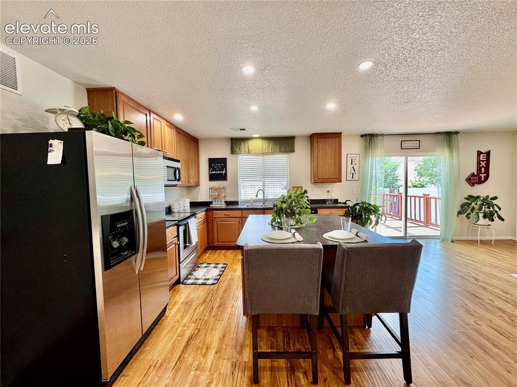 Image 11 of 36: Open-concept kitchen featuring wood-finish flooring, recessed lighting, and