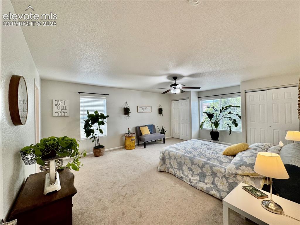 Image 18 of 36: Neutral-toned carpeting and walls complement a ceiling fan with integrated 