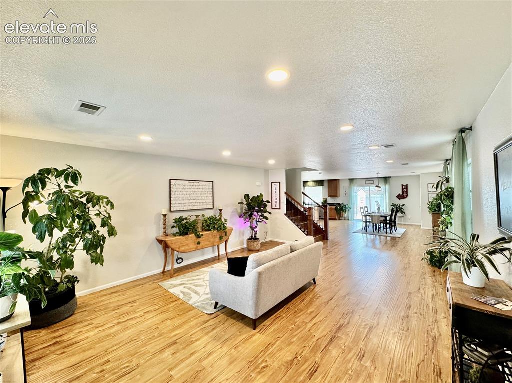 Image 2 of 36: Open-concept living space featuring wood-finish flooring, recessed lighting