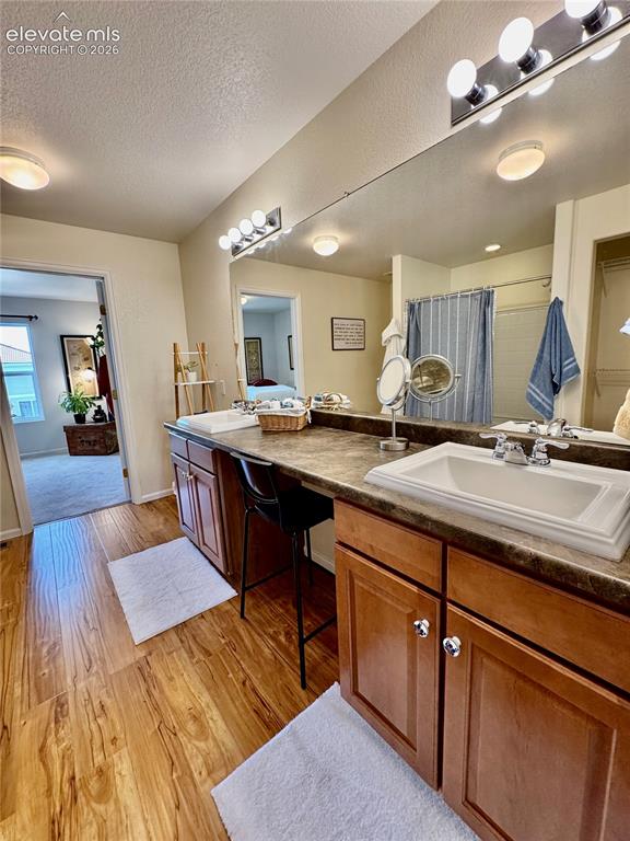 Image 22 of 36: Dual vanity with integrated sinks and wood-finish flooring