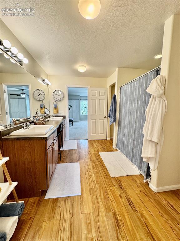 Image 23 of 36: Bathroom featuring wood-finish flooring, a double vanity with ample cabinet