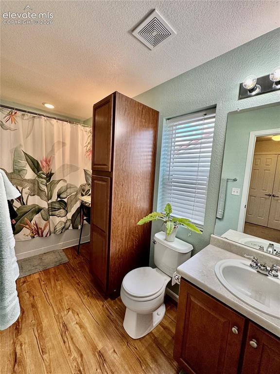 Image 27 of 36: Bathroom featuring wood-finish flooring, a vanity with a white basin sink, 