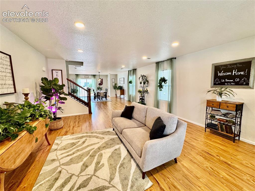 Image 3 of 36: Expansive living area featuring warm wood-finish flooring throughout