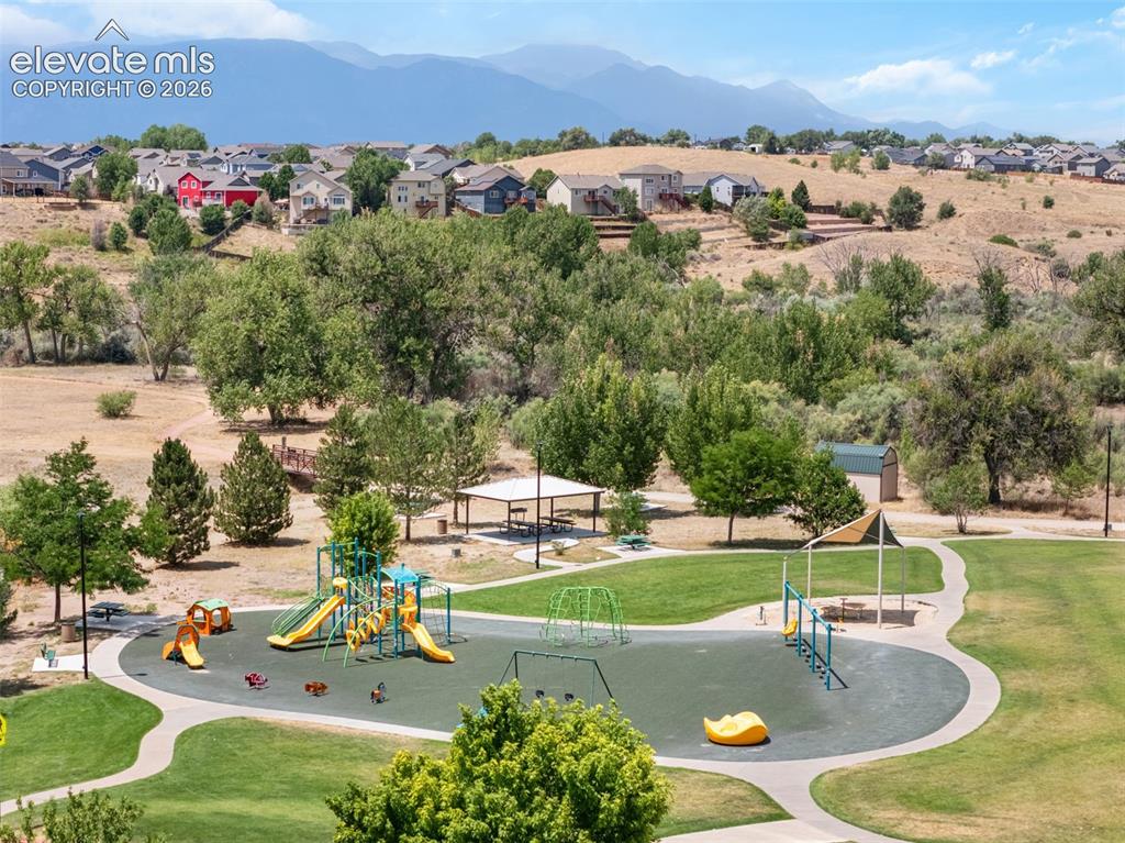 Image 43 of 43: Community park featuring a playground with slides and swings, a covered pic