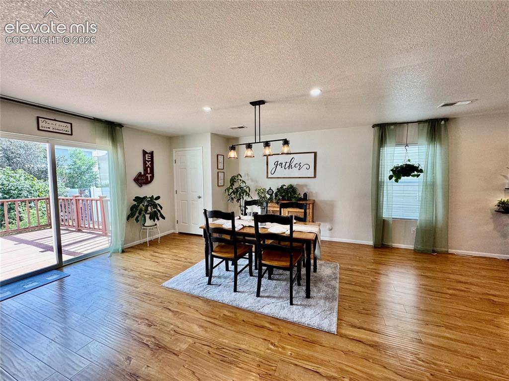 Image 6 of 36: Open-concept dining area featuring wood-finish flooring, recessed lighting,