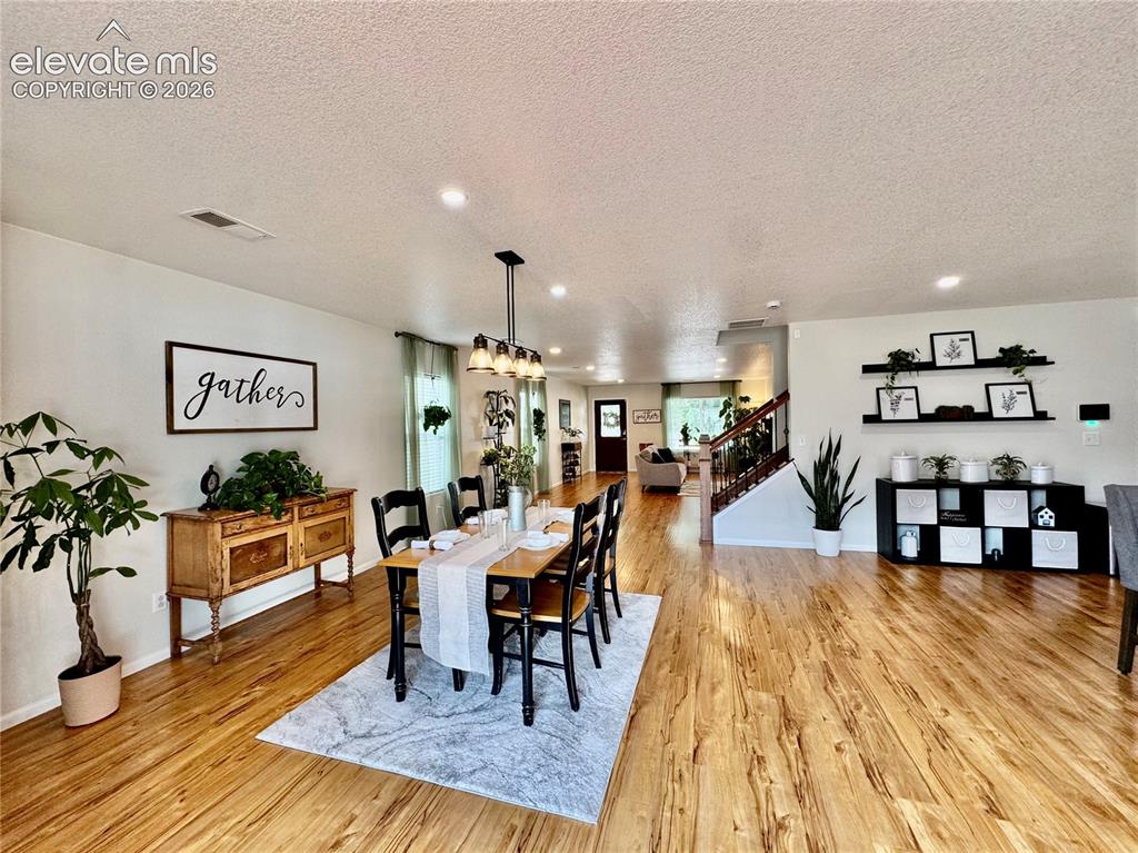 Image 7 of 43: Open-concept dining area featuring wood-finish flooring, recessed lighting,