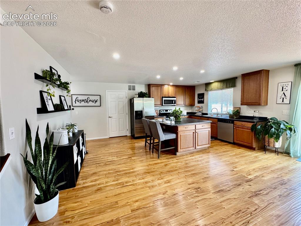Image 9 of 36: Open-concept kitchen featuring wood-finish flooring, recessed lighting, woo