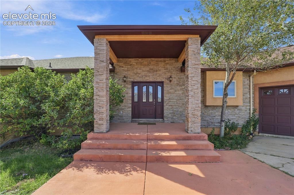 Image 39 of 48: Stacked stone exterior with welcoming covered entry
