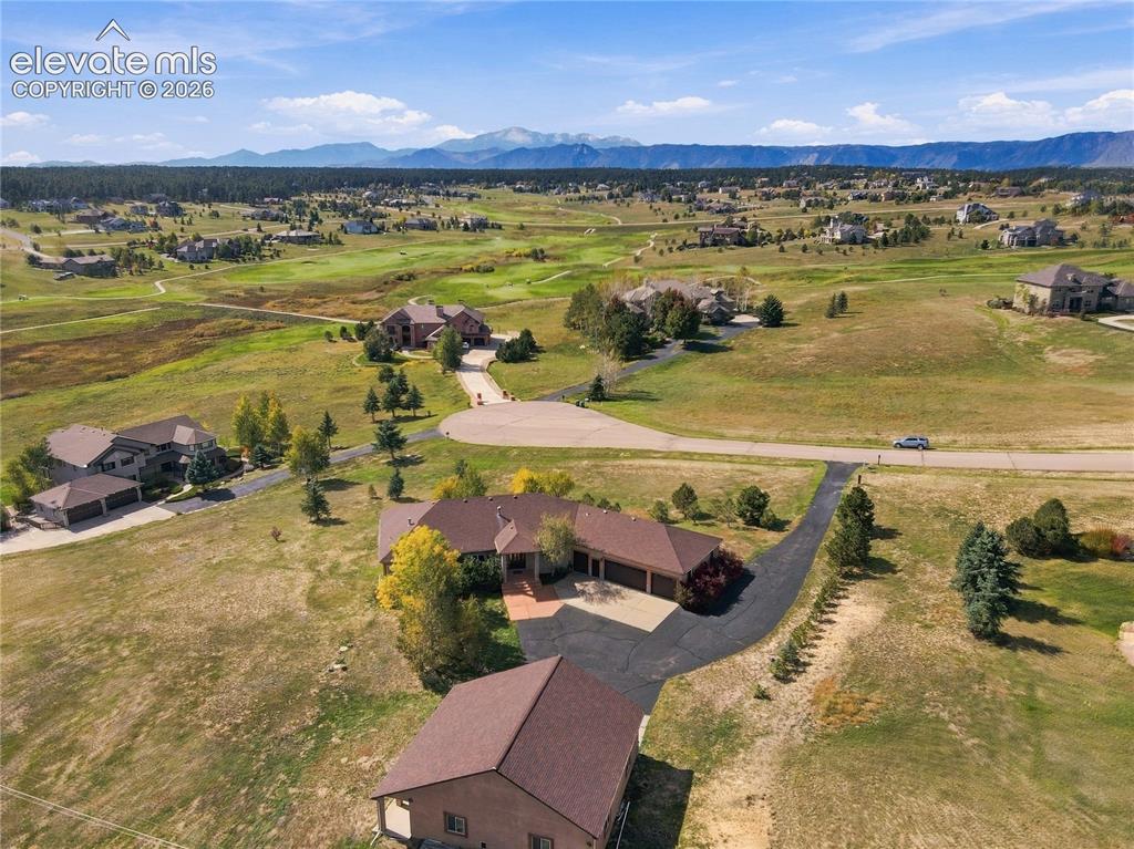 Image 42 of 48: Mountain backdrop, expansive lot, paved driveway, mature trees, multi-car g