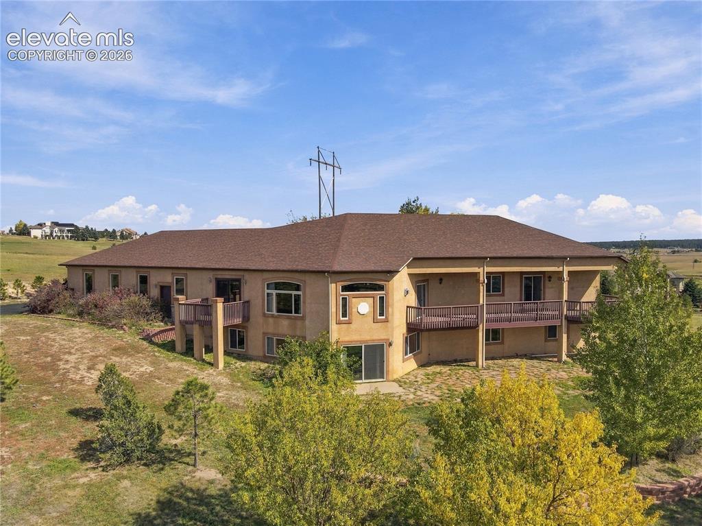 Image 44 of 48: Multiple balconies, a lower patio, and windows framing picture-perfect moun