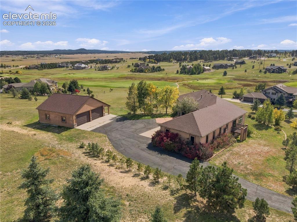 Image 48 of 48: Expansive property featuring a main residence, a detached garage structure,