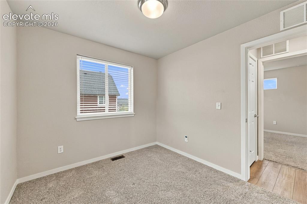 Image 17 of 30: Neutral wall color with wall-to-wall carpeting