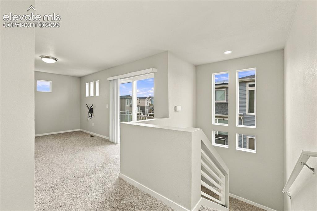 Image 3 of 30: Carpeted floor, multiple wall-mounted windows, recessed lighting, and slidi