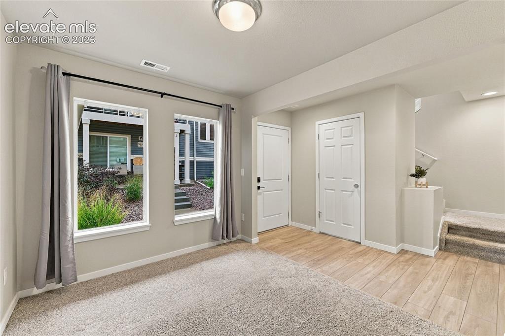 Image 7 of 30: Dual windows, neutral wall tones, wood-finish flooring, white paneled doors