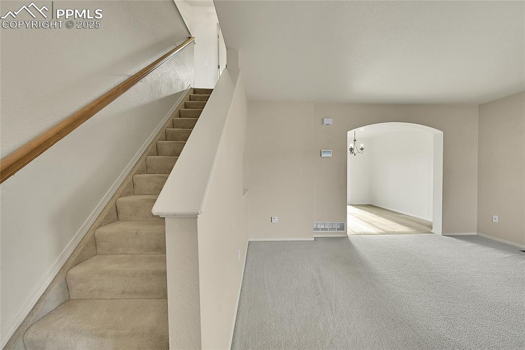 Image 5 of 39: Stairway to upstairs - archway to dining area