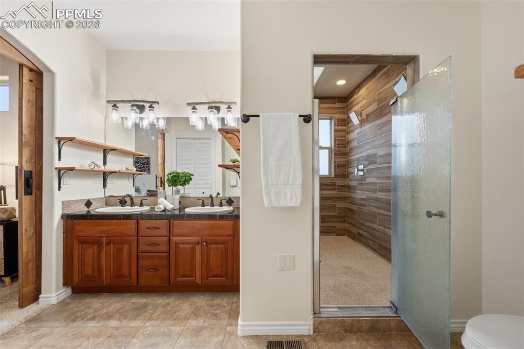 Image 19 of 50: Double sinks and spa shower room