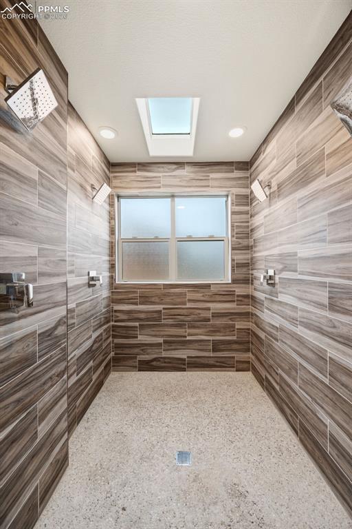 Image 20 of 50: Spa shower room has 4 shower heads and skylight for plenty of natural light