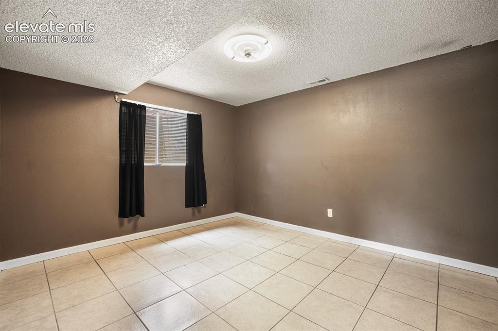 Image 40 of 49: 4th bedroom in the lower level has a big window and provides a lot of light