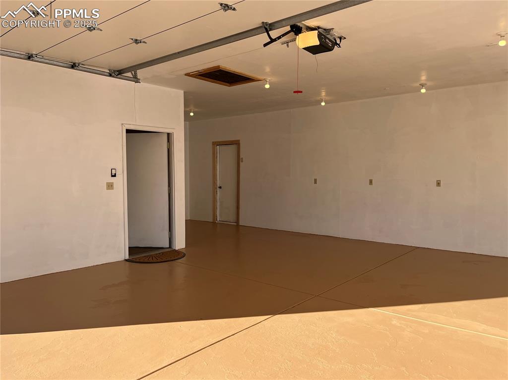 Image 5 of 10: 20 X 23 ft over-sized 2 car garage has door to office/? space and another 1