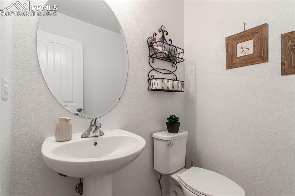 Image 14 of 41: Half bathroom with a textured wall and toilet