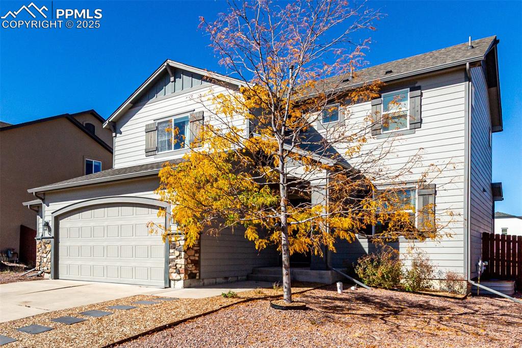 Image 2 of 41: Traditional-style house with board and batten siding, driveway, and an atta