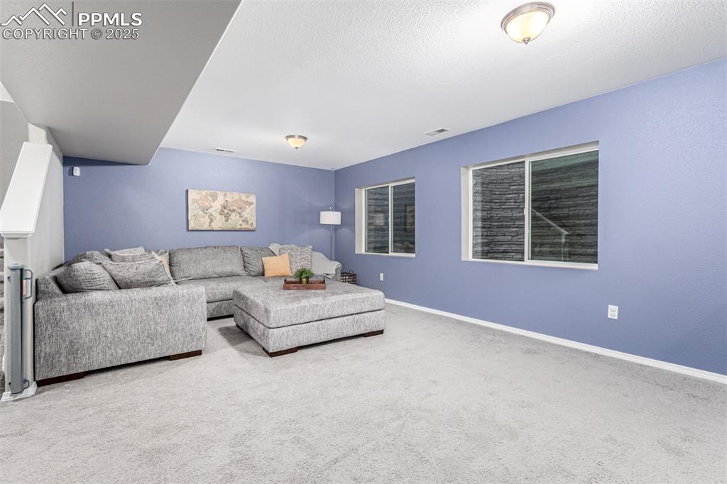 Image 26 of 41: Carpeted living area featuring baseboards and a textured ceiling