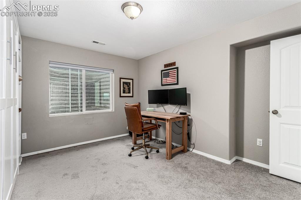 Image 31 of 41: Home office with light carpet and baseboards