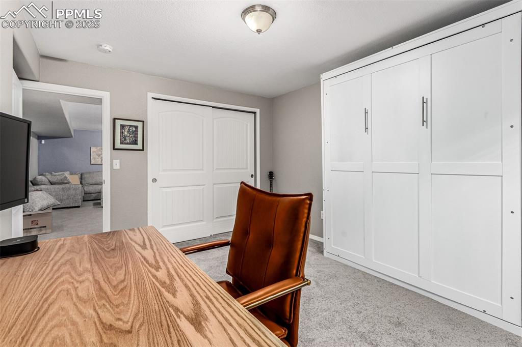 Image 32 of 41: Home office with light carpet and baseboards