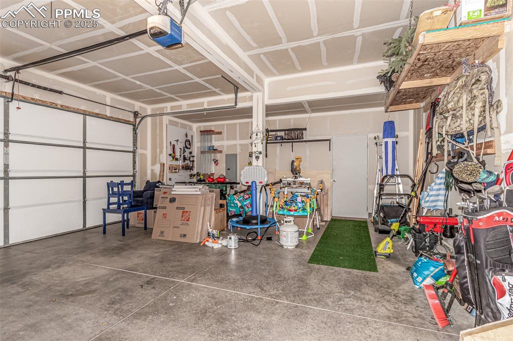 Image 35 of 41: Garage featuring a garage door opener and electric panel