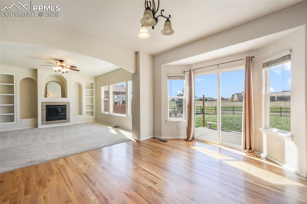 Image 3 of 50: Unfurnished living room with built in shelves, a glass covered fireplace, w