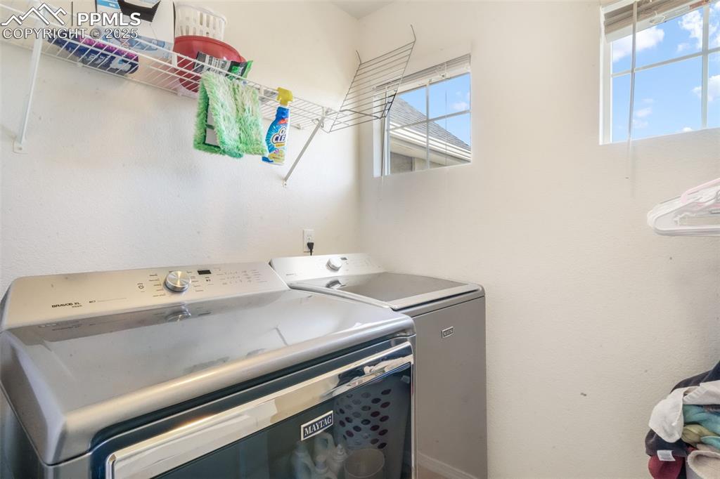 Image 35 of 50: Washroom featuring washer and dryer
