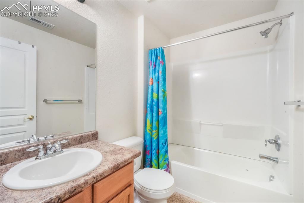 Image 40 of 50: Full bath featuring shower / bath combo with shower curtain and vanity