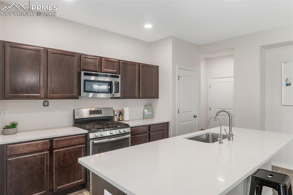 Image 12 of 25: Modern kitchen featuring an expansive island with an undermount sink and a 