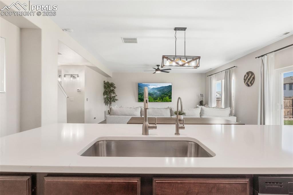 Image 13 of 25: Kitchen island with an undermount stainless steel sink and a contemporary p