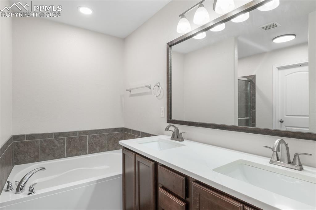 Image 17 of 25: Bathroom featuring a dual vanity with undermount sinks, white countertop, a
