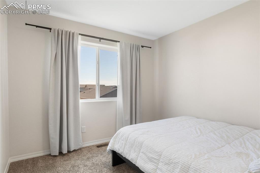 Image 18 of 25: Bright room featuring neutral wall tones, a large window, white trim, and c