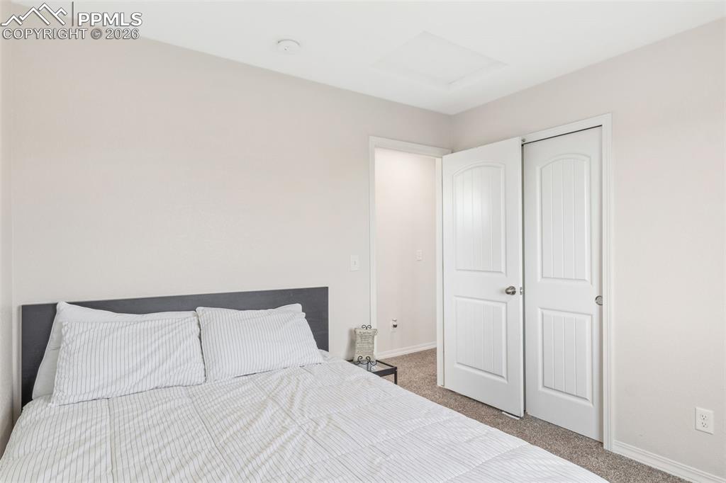 Image 19 of 25: Neutral wall paint, plush carpet flooring, white trim, and white bi-fold cl