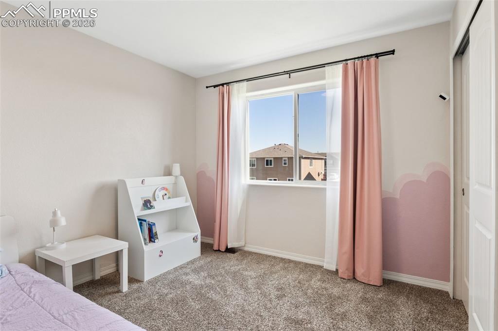Image 21 of 25: Carpeted room featuring a double window with black curtain rod, sheer white