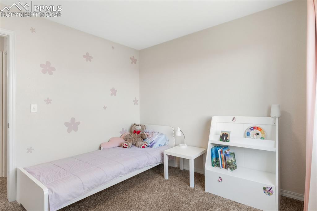 Image 22 of 25: Neutral-toned wall with subtle floral wall decals