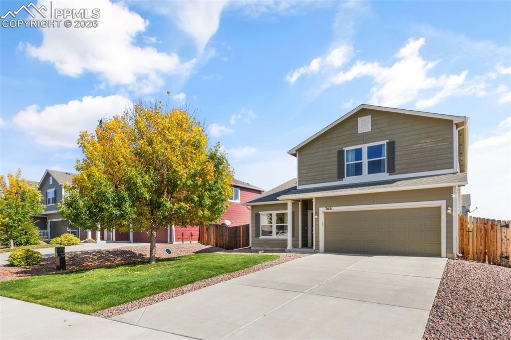 Image 4 of 25: Two-story residence featuring a two-car garage, concrete driveway, and a fr