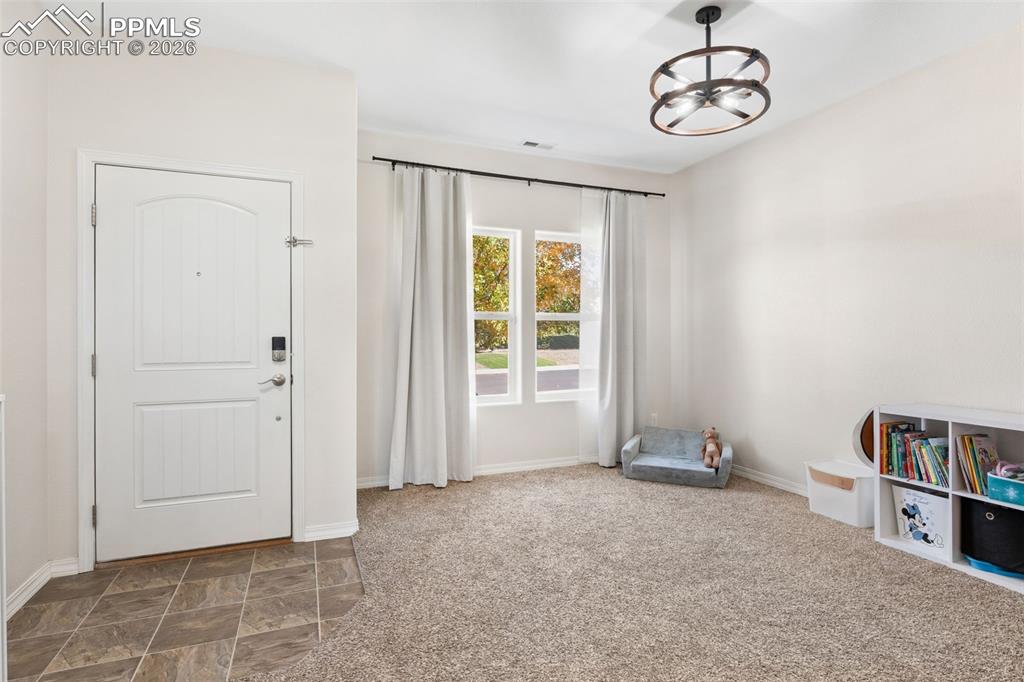 Image 5 of 25: Entryway featuring a white paneled door with an arched top, tile flooring, 