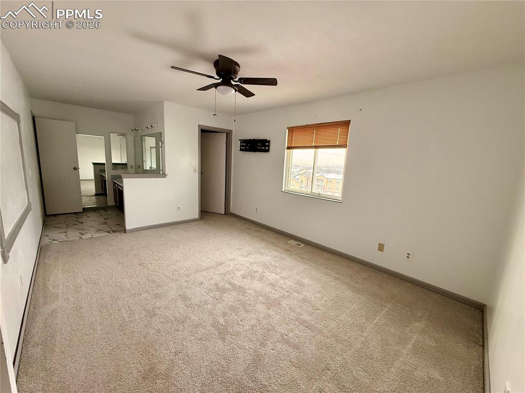 Image 14 of 42: Unfurnished bedroom featuring light carpet, ceiling fan, and connected bath