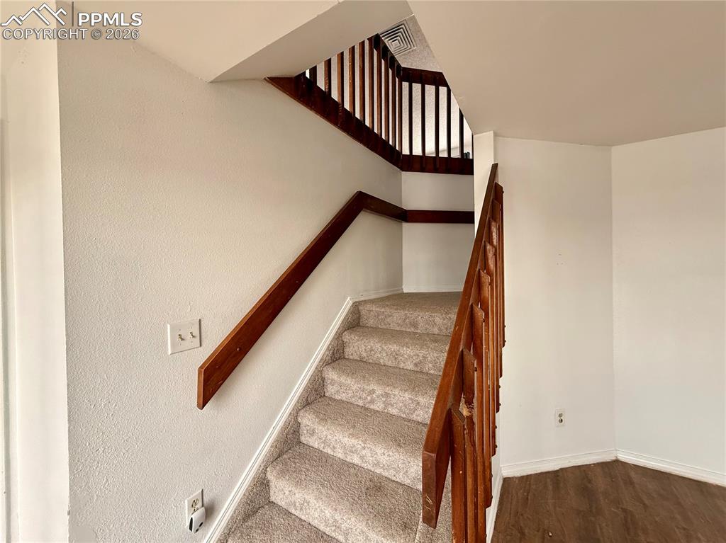 Image 22 of 42: Stairs with baseboards and wood finished floors