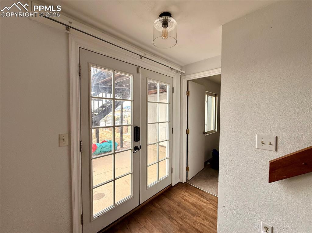Image 23 of 42: Entryway featuring a textured wall, wood finished floors, and french doors